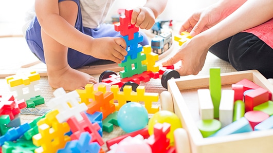 おもちゃで遊ぶ児童と先生